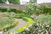 Les plates-bandes bordées de fleurs dans le jardin clos conçu par Lesley Cooper contiennent un mélange d'achillea, de verbascum et de Stipa gigantea, avec un cadran solaire au centre et des roses à l'extérieur. Beaminster Manor, Beaminster, Dorset, Royaume-Uni