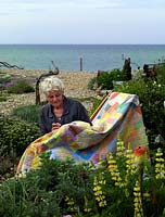 Liz Shackleton, artiste textile, travaille dans son jardin en bord de mer sur une courtepointe patchwork.