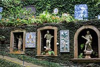 Panneaux carrelés, niches remplies de statues classiques, sculptés dans les murs du jardin tropical Monte Palace, Madère