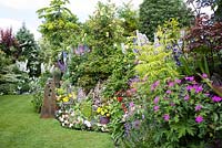 Jardin de cottage ouvert pour le programme des jardins nationaux, rempli de delphiniums, de roses et d'annuelles d'été colorées. Les paddocks, Wendover.