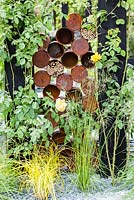 Le jardin du Great Chelsea Garden Challenge. Détail de boîtes de conserve rouillées pour les maisons d'insectes. RHS Chelsea Flower Show, 2015
