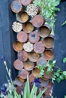 Le jardin du Great Chelsea Garden Challenge - vieilles boîtes de conserve rouillées et hôtel à insectes, habitat respectueux des abeilles