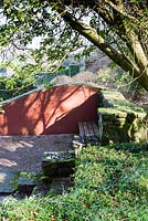 La ruine. Ombres d'arbres sur mur de forme d'onde peinte. Veddw House Garden, Monmouthshire, Pays de Galles du Sud. Mars 2015. Jardin conçu et créé par Charles Hawes et Anne Wareham