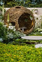 Paysages vivants 'City Twitchers' - vue sur l'étang et les zones pavées circulaires vers la peau d'oiseau de saule sphérique et le nichoir avec des plantations blanches mélangées - RHS Hampton Court Flower Show 2015