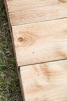 Construction d'un bac à compost en bois, étape par étape. détail des planches fixées au support principal