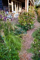 Voie d'accès à la maison en passant par les bordures de vivaces et d'herbes d'automne: Verbena bonariensis, Deschampsia cespitosa, Impatiens glandulifera. Madelien van Hasselt, Vlackeland