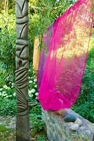 Atlante - Sculpture de Stéphane Bernard à côté de rideaux colorés
