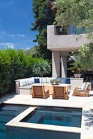 Vue sur la piscine moderne avec des chaises longues et un olivier mature.