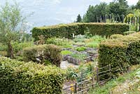 Jardin aux herbes formel, avec des carrés plantés tissés sur les côtés, à l'abri de haies Jardin des Cimes, Chamonix. France. juillet