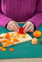 Utilisez le couteau en forme d'étoile sur la peau d'orange pour créer de petites étoiles orange