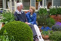 Tony et Julie Peckham dans leur jardin de la fin du printemps, assis sur les marches devant un nouveau pavillon d'été.