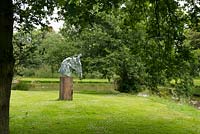 Une sculpture de tête de cheval sur un socle en bois, par l'artiste James Wild.
