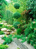 Un chemin d'ardoise et de gravier mène à travers le jardin japonais. Chelsea Flower Show 2002: Le monde merveilleux des koi. Conception: Roy Day et Steve Hickling