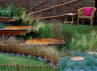 Terrasses de terrasse en bois de canoë entourées d'herbes et de clôtures en bois, HCFS 2002, The River Cam, Design: Jo Montague Fuller