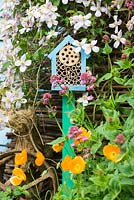 Jardinage de la faune - jardin au début de l'été avec une boîte à insectes montée sur poteau placée dans une zone de jardin riche en nectar.