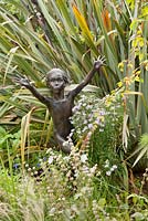 Jardin clos, Cambo, Fife, Scotland, UK. Statue en bronze par Asters et phormium