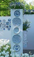 Toutes sortes de motifs conçus par Delfts Blue sur des plaques suspendues à un mur. Muscari blanc et bleu, tulipes blanches et narcisse. Jardin d'inspiration: Delfts Blue.
