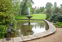 Pashley Manor Gardens, Kent, UK - Montrant la fontaine d'eau dans le lac avec sculpture 'Hésitation' par Mary Cox et maison en arrière-plan
