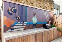Murale peinte par Lauren Mele derrière le barbecue du London Roof Terrace Garden