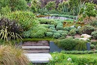 Une sélection de Hebes, Phormiums et arbustes et arbres indigènes au jardin Bhudevi Estate, Marlborough, Nouvelle-Zélande.