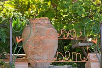 Casa Cuseni écrite dans les grilles du jardin, derrière une grande urne en terre cuite. Casa Cuseni à Taormina, Sicile, Italie