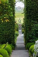 Découvre les marches de Neptune en passant par les haies de Quercus Ilex jusqu'à la sculpture - 'Tresco Children' de David Wynne. Jardin de l'abbaye de Tresco, Tresco, îles Scilly.
