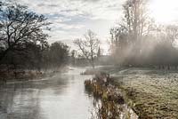 La brume s'élève de la rivière Lambourn qui traverse le parc de Welford Park, Newbury, Berks, UK
