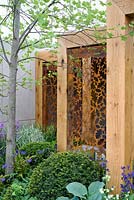 Paravent en métal rouillé au pochoir dans un cadre en bois. Le jardin Morgan Stanley pour l'hôpital Great Ormond Street. RHS Chelsea Flower Show 2016