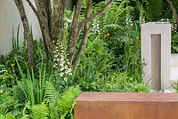 Garden of Mindful Living, un jardin contemporain avec un plan d'eau en pierre calcaire, des murs en blocs et en acier corten, des arbres à plusieurs tiges et des parterres d'ombre avec Blechnum tabulare, Hosta 'Devon Green', Matteuccia struthiopteris, Dryopteris erythrosora et Digitalis purpurea 'Dalmatian White '. The RHS Chelsea Flower Show 2016 - Designer: Paul Martin - Sponsor: Vestra Wealth LLP - OR