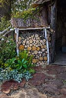 Magasin de billes et pierres de gué en troncs d'arbres. Le jardin du bûcheron, RHS Malvern Spring Festival 2016. Conception: Mark Walker