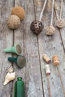 Une variété de matériaux pouvant être utilisés comme garnitures de canne. Balles tressées, balles de tennis, bouchons de vin, coquillages, vases et bouteilles en verre