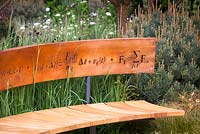 Banquette incurvée ornée de symboles mathématiques taillés en bande de cuivre formant dossier. The Winton Beauty of Mathematics Garden, RHS Chelsea Flower Show 2016