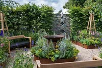 Une salle de jardin inspirée des arts et de l'artisanat avec un plan d'eau, des parterres en acier corten surélevés et des bancs fabriqués à la main. Une retraite d'été conçue par Laura Arison et Amanda Waring. Exposition florale de Hampton Court 2016