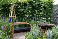 Une salle de jardin inspirée des arts et de l'artisanat avec un plan d'eau, une haie de charme et un banc artisanal entouré de vivaces. Une retraite d'été conçue par Laura Arison et Amanda Waring. RHS Hampton Court Flower Show 2016