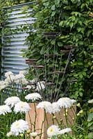 Une sculpture contemporaine en métal sur un socle en chêne. Un jardin de retraite conçu par Martin Royer. Exposition florale de Hampton Court