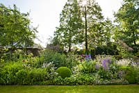 Le parterre d'été comprend Salvia x sylvestris 'Dear Anja', Delphinium Belladonna-Hybride 'Piccolo', Rosa 'Rhapsody In Blue', Geranium riversleaianum 'Russel Prichard '. Sarina Meijer garden