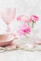 Renoncule rose dans des pots en verre dans un arrangement avec des coeurs et des perles