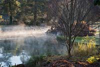 Un brouillard se lève de la piscine du puits dans le jardin du palais épiscopal de Wells par une froide matinée de novembre