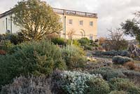 Le jardin Boulder où poussent des plantes méditerranéennes parmi les rochers et les éboulis, avec la Maison de la Principauté derrière en décembre