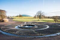 La grande serre conçue par Norman Foster avec une pièce d'eau circulaire avec des jets d'eau au premier plan en décembre