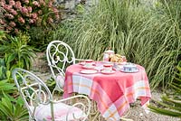 Set de table pour le thé parmi les échiums, les cortaderia et les hortensias.