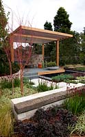 Un pavillon entouré d'érables japonais, de pattes de kangourou, d'herbes, d'euphorbes et de Loropetalum chinense var. rubrum 'Bourgogne'