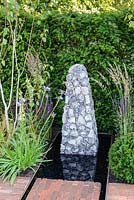 Sculpture en silex au bout de l'eau, Summer's Streetscape's Sussex Garden, RHS Hampton Court Palace Flower Show 2016. Conçu par Will Williams