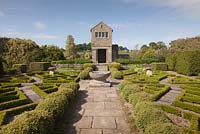 Le jardin de fantaisie avec gazebo en pierre et motif rose Tudor fabriqué à partir de la boîte - juin, Herterton House, Hartington, Northumberland, UK