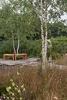 Bancs en bois incurvés devant un jardin de style prairie contemporain avec haie indigène avec ruisseau - 'Nature et culture' au RHS Tatton Park Flower Show 2016
