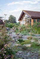 Little Ash Garden, Fenny Bridge, Devon. Jardin d'automne. Grand jardin de gravier en face de l'extension de bungalow moderne