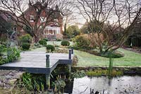 Terrasse en bois givré à côté de l'étang dans le jardin arrière à Windy Ridge, Little Wenlock, Shropshire, Royaume-Uni