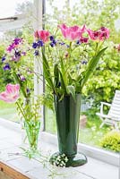 Tulipes roses, persil de vache et aquilegias affichés dans un vieux seau à fleurs en émail
