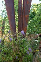 Buddleja davidii auto-ensemencé à côté d'une structure en acier rouillé - Brownfield Metamorphosis, RHS Hampton Court Palace Flower Show 2017