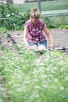 Jessica Zwartjes mesure la distance des fentes pour planter de jeunes plants.